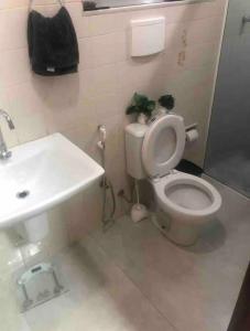 a bathroom with a white toilet and a sink at Linda Casa com Estacionamento in Juiz de Fora