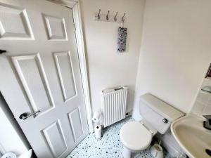 a white bathroom with a toilet and a sink at Comfortable House near Etihad - Stay Sleep Rest in Manchester