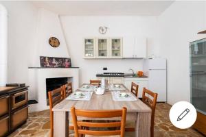 eine Küche mit einem Holztisch und Stühlen im Zimmer in der Unterkunft Albero della musica in Sassari