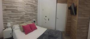 1 dormitorio con 1 cama con 2 almohadas rojas en Apartamento con barbacoa BBQ Los picadores, en Córdoba