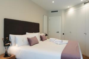 A bed or beds in a room at RAMBLA POBLENOU Luxury