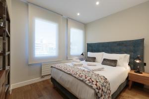 A bed or beds in a room at RAMBLA POBLENOU Luxury