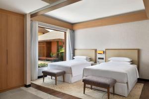 Duas camas num quarto com uma janela em Mulberry Shades Bengaluru Nandi Hills - a Tribute Portfolio Resort em Bangalore