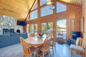 a dining room with a wooden table and chairs at Bright Minong Vacation Rental on Little Sand Lake! in Minong