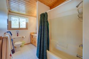 a bathroom with a shower curtain and a toilet at Bright Minong Vacation Rental on Little Sand Lake! in Minong +37 photos