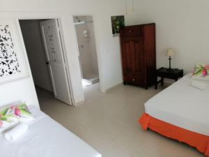 a bedroom with two beds and a wooden cabinet at Hotel campestre La Floresta in Armenia