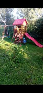 a playground with a slide and a play house at Na wzgórzu in Krośnica