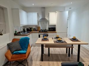 cocina con mesa de madera y comedor en Central Watford Modern Apartment - Travellers & Contractors Welcomed, en Watford