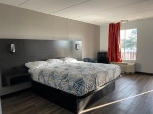 una camera con un grande letto e pavimenti in legno di Motel 6 Stockbridge GA Hwy 138 W a Stockbridge