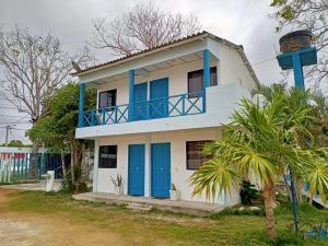 una casa con puertas azules y una torre en Cabañas Cigua en Coveñas