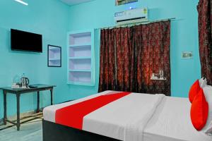 Schlafzimmer mit einem Bett, einem Schreibtisch und einem TV in der Unterkunft OYO Flagship Hotel Baba''s House in Kakarmatha