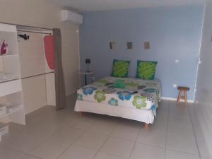 een slaapkamer met een bed met groene kussens en een douche bij Residence vue sur mer in Le Marin