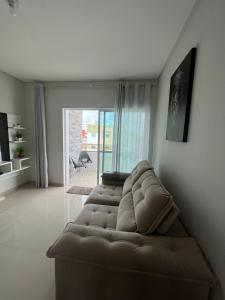 ein Wohnzimmer mit einer braunen Couch in einem Zimmer in der Unterkunft Apartamento LION in João Pessoa