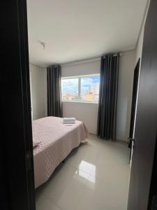 ein kleines Schlafzimmer mit einem Bett und einem Fenster in der Unterkunft Apartamento LION in João Pessoa