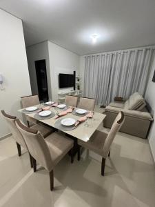 ein Esstisch und Stühle in einem Wohnzimmer in der Unterkunft Apartamento LION in João Pessoa