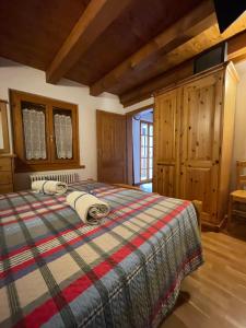1 dormitorio con 1 cama en una habitación con paredes de madera en Dependance GRIMANI, en Ampezzo