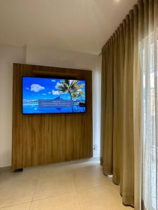 TV de pantalla plana en la pared de una habitación en Stúdio Royal Central piscina/academia/coworking en Juiz de Fora