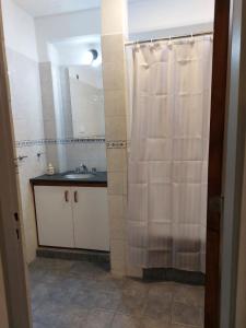 a bathroom with a shower curtain and a sink at Departamentos PLAZA, a 12 metros de la catedral y plaza principal in San Fernando del Valle de Catamarca