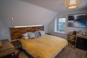 a bedroom with a large bed with a wooden headboard at Magnolia House, Rye in Rye