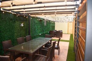 a dining room with a green wall with a table and chairs at Waikiki Beachside Hostel in Honolulu
