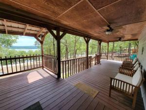 a large wooden porch with chairs and a ceiling fan at Gigi's Spacious Lakefront with Boat Ramp Access!! Newly Remodeled, Sleeps 8! in Canadian