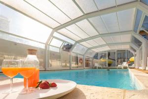 a table with glasses of orange juice and strawberries next to a swimming pool at 731 Costa Cabral Metro Residence in Porto