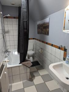 a bathroom with a tub and a toilet and a sink at Flensburg Zentrum 10 VH 2OG R in Flensburg