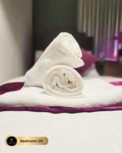 toalla enrollada encima de la cama en Nr Birmingham City Centre, 5 Bed, Luxe Inn en Birmingham