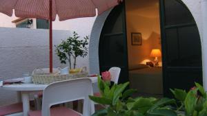 a table and chairs with an umbrella on a patio at Casa Mamma Bruna in San Vito lo Capo