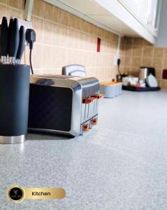 a toaster oven sitting on a counter in a room at Nr Birmingham City Centre, 5 Bed, Luxe Inn in Birmingham