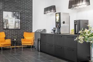 a kitchen with two orange chairs and a refrigerator at Best Western Leto Arena in Dal