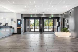 an office lobby with doors and a plant in the middle at Best Western Leto Arena in Dal