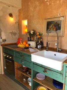 uma cozinha com um lavatório e algumas frutas num balcão em Charming and Design Attic Loft Central Milan in coolest area Navigli Ticinese em Milão