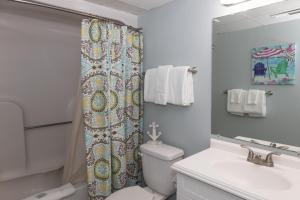 a bathroom with a toilet and a shower curtain at 0412 Memories Made At The Beach by Atlantic Towers in Carolina Beach