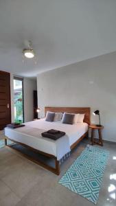 a bedroom with a large bed and a rug at Sweet Tulum 202 in Tulum