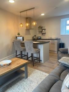 a living room with a couch and a table and a kitchen at Maple Valley Guesthouse in Limerick