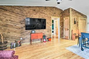 sala de estar con pared de madera y TV de pantalla plana en Peaceful Nutrioso Cabin Retreat with Fire Pit!, en Nutrioso