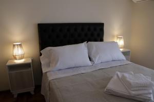 ein Bett mit weißen Kissen und zwei Nachttischen in der Unterkunft Parana 540 - Nueva Córdoba in Cordoba