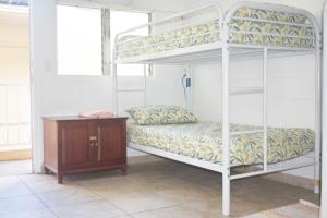 ホノルルにあるワイキキ ビーチサイド ホステルのベッドルーム1室(二段ベッド2組、木製テーブル付)