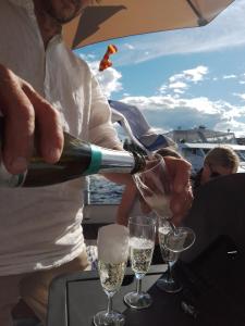 facet nalewający szampana do kieliszków na łodzi w obiekcie Saimaa Experience w mieście Savonlinna