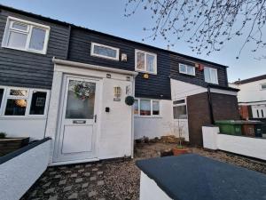 a house with a white door and a garage at Spacious & comfy Home- very close to NEC Birmingham ,HS2 & Airport- Perfect for contractors & groups- free parking & Fast WiFi in Marston Green