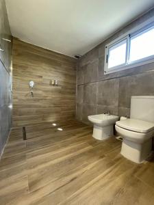 a bathroom with a toilet and a sink at DelViento Cabañas in Las Rabonas