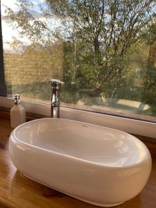 a white sink in a bathroom with a window at DelViento Cabañas in Las Rabonas