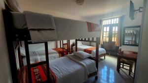 a bedroom with two bunk beds and a window at Chachapoyas Backpackers Hostal Boutique in Chachapoyas