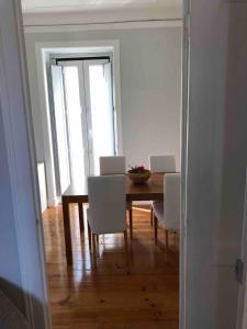 ein Esszimmer mit einem Tisch und weißen Stühlen in der Unterkunft Angels Homes-n27, 2ºfloor - Bairro Tipico, Centro Lisboa in Lissabon