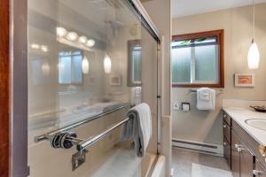 a bathroom with two sinks and a glass shower at Water's Edge Oceanside Home in Waldport +31 photos