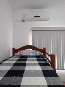 1 dormitorio con 1 cama con alfombra blanca y negra en Casas de praia maranduba UBATUBA, en Ubatuba