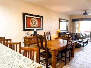 a living room with a wooden table and chairs at Sandy Beach Princesa A103 Ocean Front Resort in Puerto Peñasco