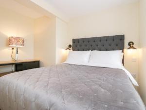 a bedroom with a large bed and a lamp at How Hill Farm Cottage in Penrith