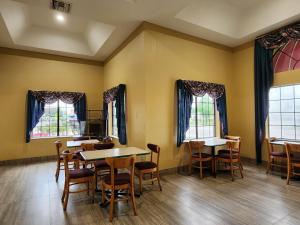 a dining room with tables and chairs and windows at Express Inn Hobby Airport in Houston